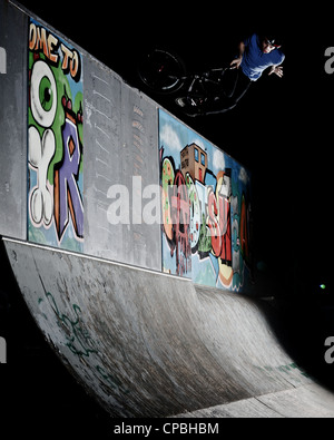 BMX rider führt Tricks bei einem indoor Skatepark. Stockfoto