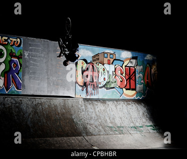 BMX rider führt Tricks bei einem indoor Skatepark. Stockfoto