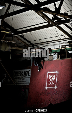 BMX rider führt Tricks bei einem indoor Skatepark. Stockfoto