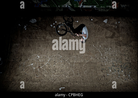 BMX rider führt Tricks bei einem indoor Skatepark. Stockfoto