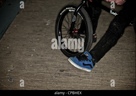 BMX rider führt Tricks bei einem indoor Skatepark. Stockfoto