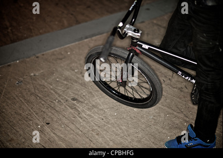 BMX rider führt Tricks bei einem indoor Skatepark. Stockfoto