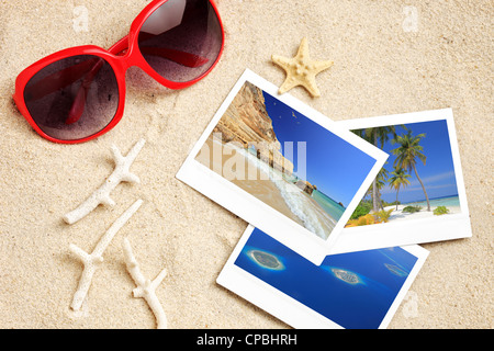 Eine Sonnenbrille, paar Fotos, Seesterne und Korallen am Sandstrand Stockfoto