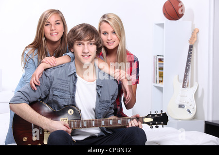 Drei Jugendliche im Schlafzimmer mit e-Gitarre Stockfoto