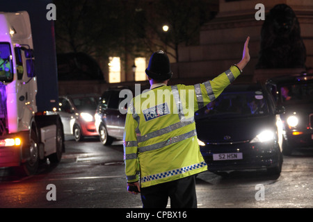 Metropolitan Police Officer regelt den Verkehr im Zentrum von London in der Nacht. Stockfoto