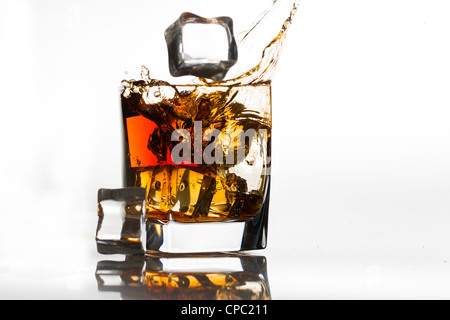 Eiswürfel in einem Cognac-Schwenker fallen Stockfoto