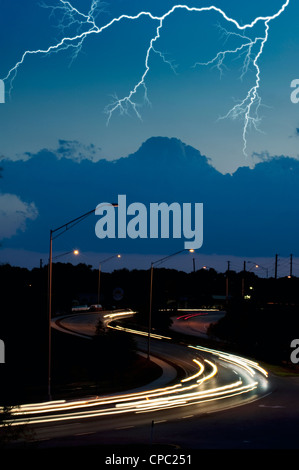 Blitz am Nachthimmel über Autobahn Stockfoto