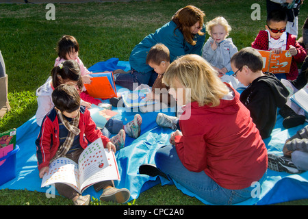 Freiwilliger Lehrer ermutigt junge Kinder zu lesen, zu einem Outdoor-"Dr. Seuss jährliche Alphabetisierung Fair" in Kalifornien. Stockfoto