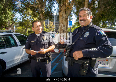 Zwei Polizisten der hispanischen Santa Ana, CA, treffen während einer Tätern. Stockfoto