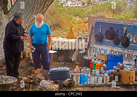 Obdachloser spricht mit Hispanic Vertreter einer lokalen Wohltätigkeitsorganisation in ein Outdoor-Lager in der Wüste von Victorville, Stockfoto