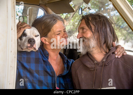 Mittellose Ehepaar und ihr Hund Leben in einen LKW Wohnmobil unter Obdachlosen Bewohner von einem primitiven Outdoor-Lager in der Wüste. Stockfoto