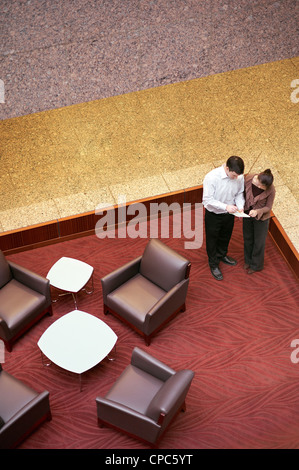 Menschen im Chat in der Lobby eines Bürogebäudes. Stockfoto