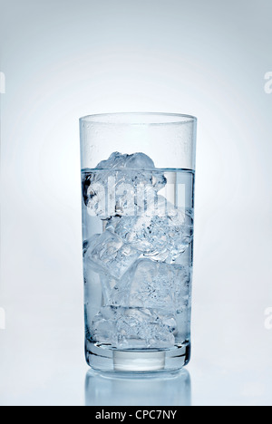 Trinken Sie mit Eiswürfeln vor einem blauen Hintergrund. Stockfoto