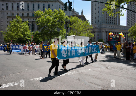 Banner und Schilder Mitglieder der Falun Dafa aus rund um die Welt-Parade durch die Straßen von Chinatown in New York Stockfoto