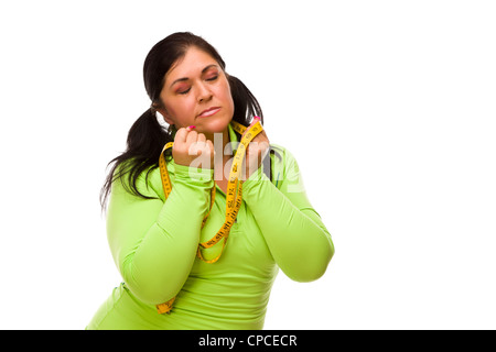 Attraktive frustriert Hispanic Frau mit Maßband vor einem weißen Hintergrund. Stockfoto