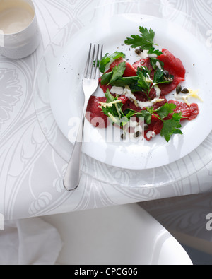 Teller mit Rindfleisch-Carpaccio auf Tisch Stockfoto