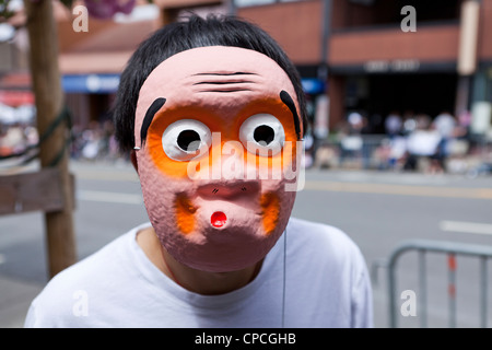 Ein junger Mann mit einer japanischen Hyottoko-Maske Stockfoto