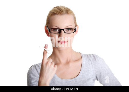 Frau versucht sich zu erinnern was das Stück Schnur Runde, wie ihr Finger sie, isoliert auf weißem Hintergrund erinnern soll. Stockfoto