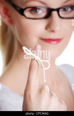 Frau versucht sich zu erinnern was das Stück Schnur Runde, wie ihr Finger sie, isoliert auf weißem Hintergrund erinnern soll. Stockfoto