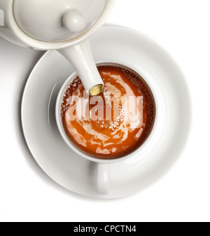 Tee in Teetasse gegossen wird isoliert auf weißem Hintergrund. Stockfoto