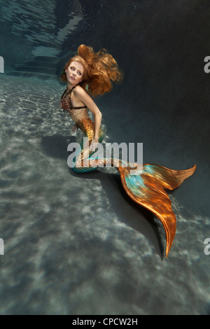 Junge blonde Meerjungfrau an der Unterseite eines Pools in Virginia Beach, Virginia Stockfoto