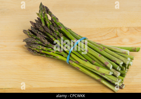 Spargel frisch geerntet und gebündelt zum Verkauf auf einem Holzbrett Stockfoto