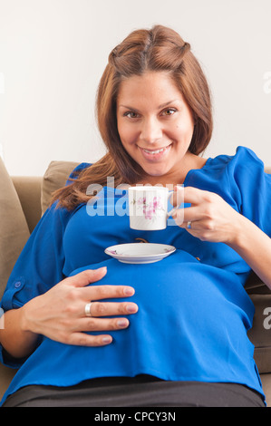 Lächelnd schwangere Frau Kaffee trinken Stockfoto