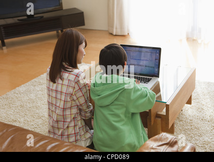 Mutter und Sohn Blick auf laptop Stockfoto