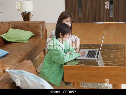 Mutter und Sohn Blick auf laptop Stockfoto