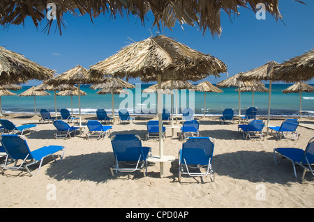 Liegen unter Palme Blätter Sonnenschirme am Strand Stockfoto