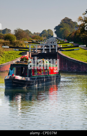 Ein Grachtenboot verlassen der berühmten Serie von Schlössern in Caen Hill auf der Kennet und Avon Kanal, Wiltshire, England, Vereinigtes Königreich Stockfoto