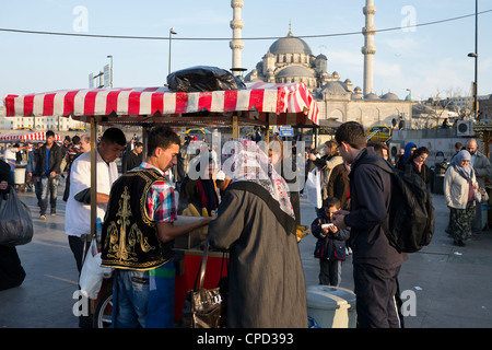 Türkische Frau mit Schleier kaufen von Mais Anbieter auf neue Moschee, Istanbul, Türkei Stockfoto