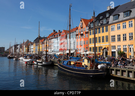 Am Kanal in Nyhavn, Kopenhagen, Altstadt Hafen berühmt für die alte bemalte Häuser, direkt am Wasser Restaurants, Bars und Kreuzfahrten Stockfoto