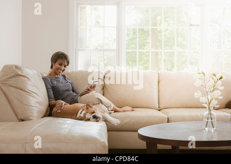 Indianische Frau entspannend auf Sofa mit Englisch bulldog Stockfoto