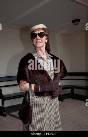 1940er Jahre gekleidete Frau stehend in einem Tierheim Stockfoto