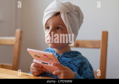 Kleiner Junge spielt auf Nintendo DS-Spiel-Konsole Stockfoto