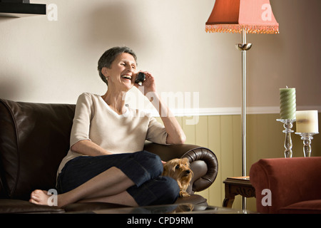 Ältere Frau auf Sofa am Telefon sprechen Stockfoto