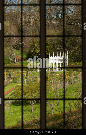 Frühling-Blick durch ein Fenster in das Haus Adler in Richtung der Exedra und Nutzgärten, Painswick Rokoko-Garten Stockfoto