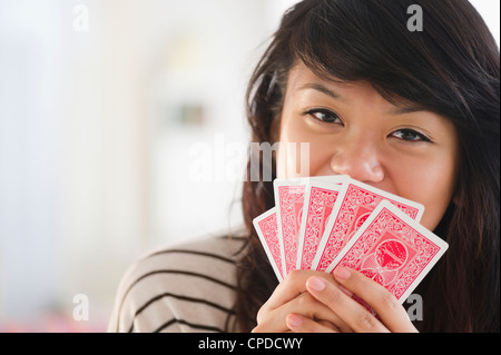 Pacific Islander Frau ihr den Mund mit Spielkarten Stockfoto