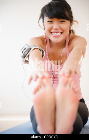 Pacific Islander Frau stretching vor dem Training Stockfoto