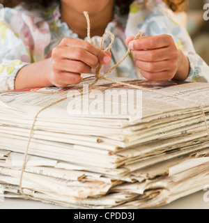 Gemischte Rassen Mädchen binden Bündel Zeitungen Stockfoto