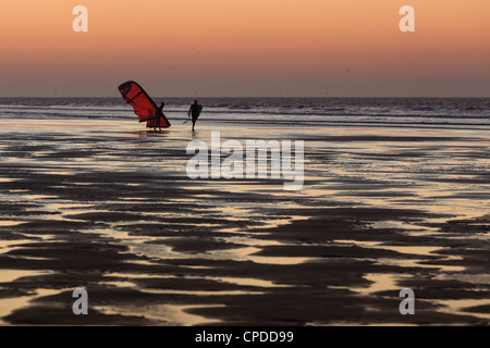 Zwei Männer am Strand bei Sonnenuntergang Spaziergang mit einem Kite Surfer, Essaouira, Marokko Stockfoto