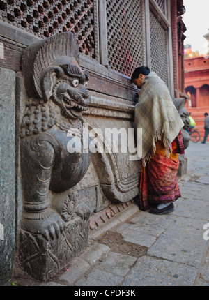 Stein-Löwen bewachen eine Gebet Wand in Durbar Square, Kathmandu, Nepal, Asien Stockfoto
