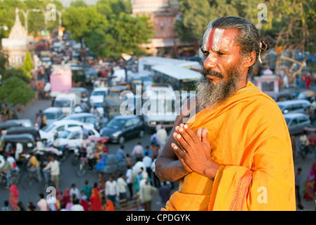 Heiligen Sadhu meditieren hoch über Verkehr Staus und Straße leben in der Stadt Jaipur, Rajasthan, Indien, Asien