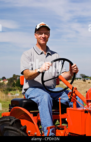 Clunes Australien / ein 1948 Modell Allis Chalmers Traktor und der stolze Besitzer und Restaurator der historischen Fahrzeug zeigen. Stockfoto