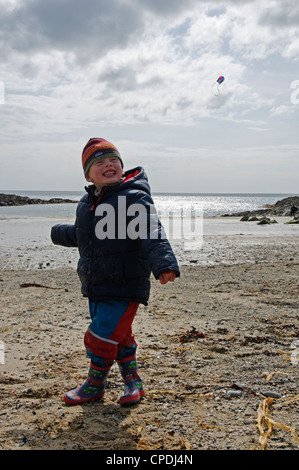 Ein kleiner Junge einen Drachen am Strand Stockfoto