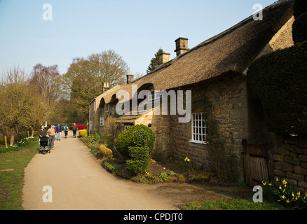 Personen an strohgedeckten Dach Hütten in der Nähe von Dorf Baslow Derbyshire England Stockfoto