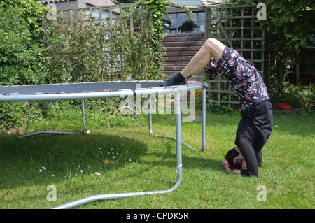 Eine Frau praktiziert Yoga mit einem Trampolin Stockfoto