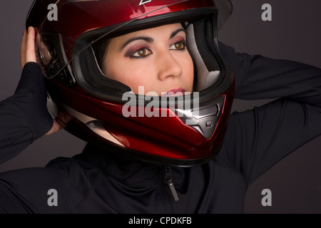 Ein roten Integralhelm ist von einer Frau-Fahrer setzen auf Stockfoto