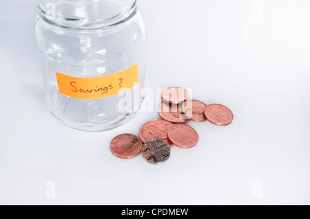 Glas etikettiert "Einsparungen?" mit wenig Kleingeld vor weißem Hintergrund Stockfoto